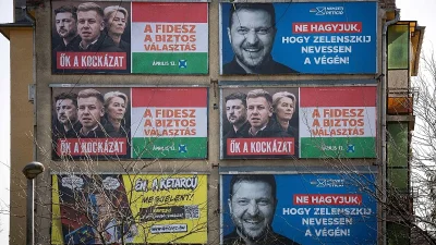 A building covered in Fidesz election billboards, several showing a laughing Volodymyr Zelensky.