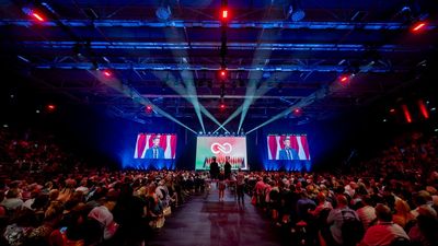 A packed arena at the Tisza Party congress, with a speaker on big screens either side of the party logo.