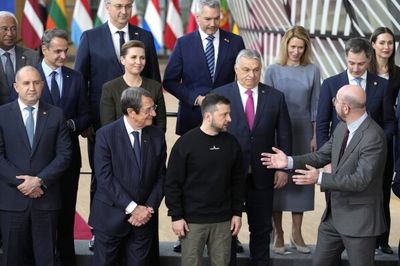 EU leaders posing for a group photo, with Volodymyr Zelensky in a black sweatshirt standing in front of Viktor Orbán.